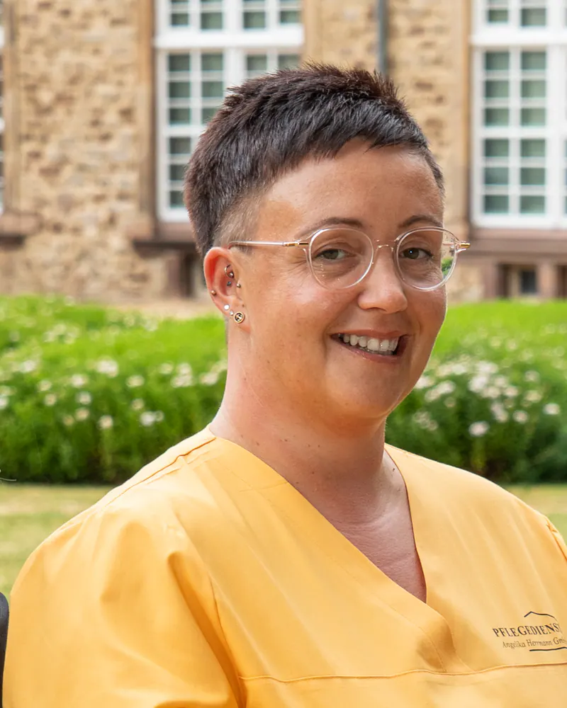 Pflegekraft des Pflegedienstes Angelika Herrmann in gelber Dienstkleidung