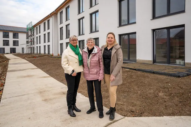 Drei Frauen vor der neuen Wohnanlage