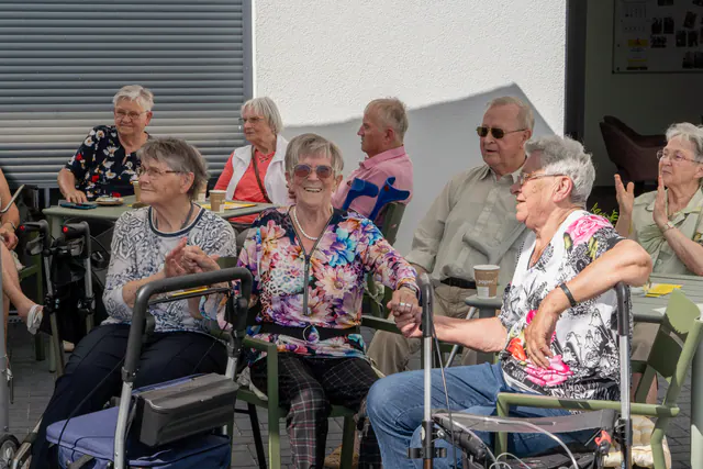 Bewohner und Gäste beim Sommerfest im Hof des Ritterguts